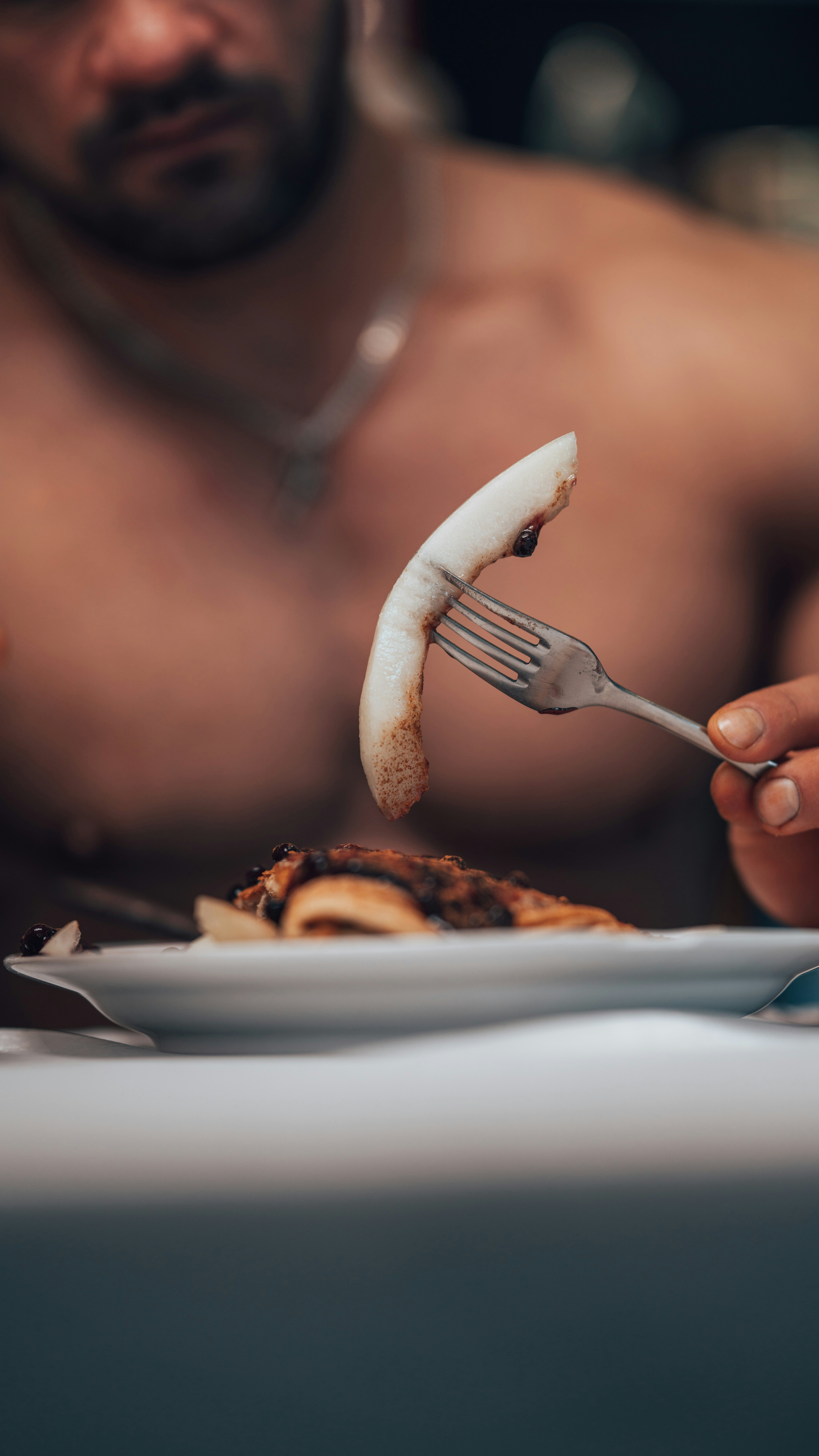 a man holding a fork and knife over a plate of food