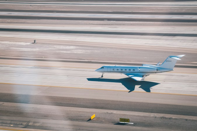 A small general aviation airplane flying low over the ground near the runways at the Las Vegas airport