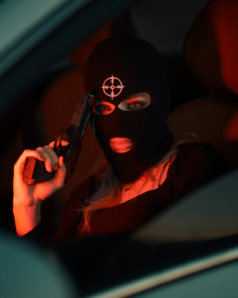 a woman in a black mask holding a gun