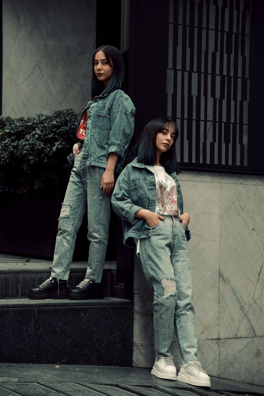 two young women standing on the steps of a building
