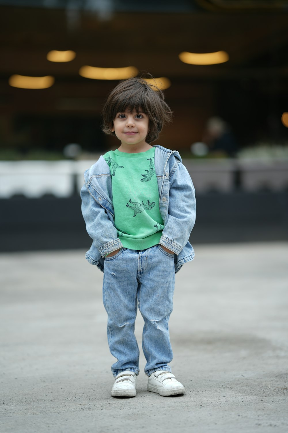 a young boy standing in a parking lot