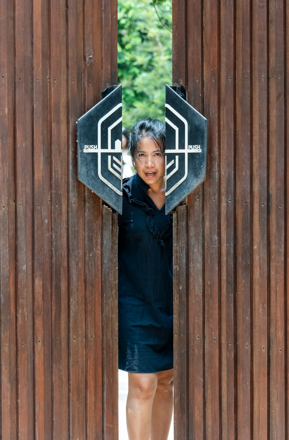 a woman standing in front of a wooden wall