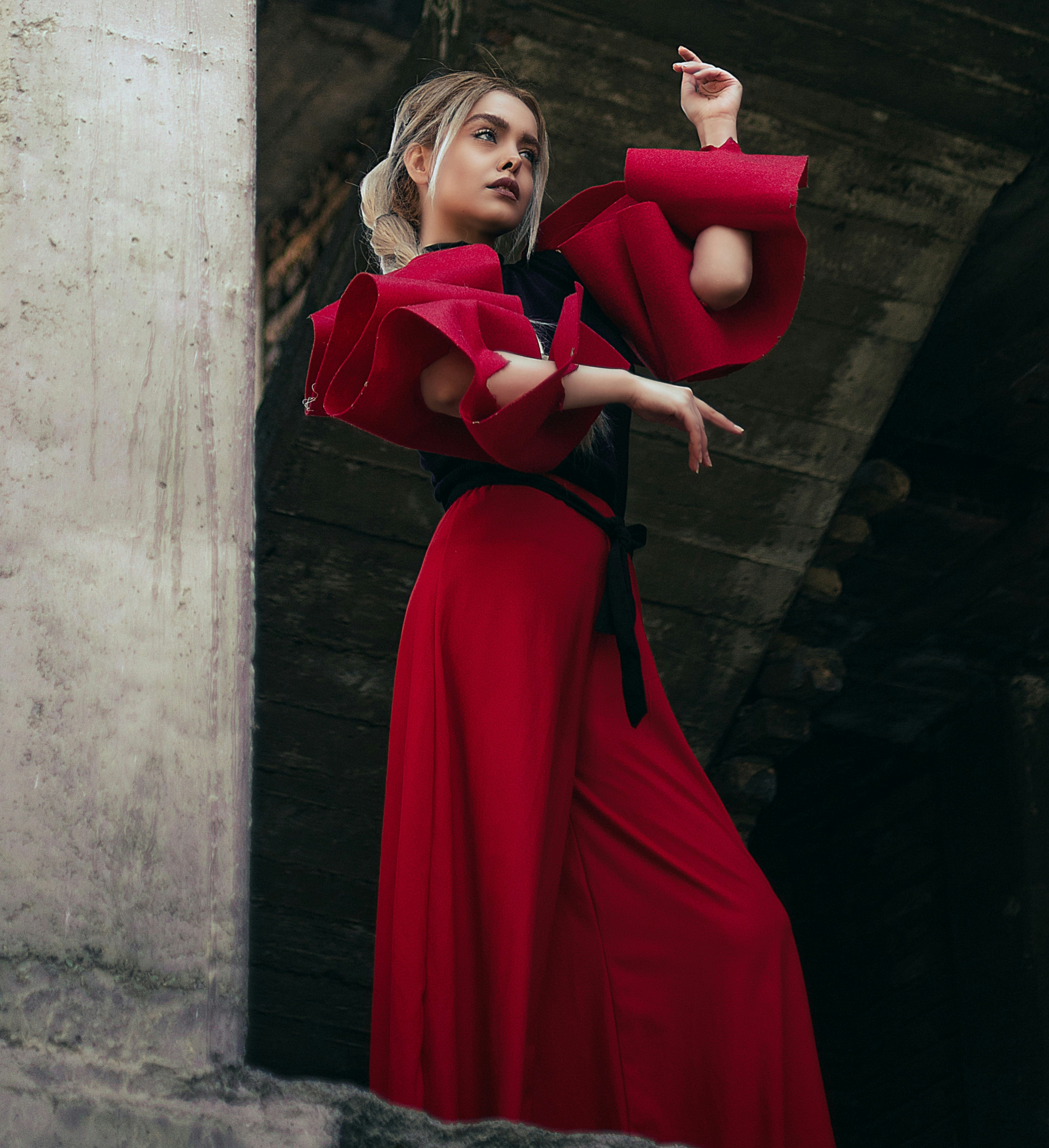 a woman in a long red dress holding a cigarette