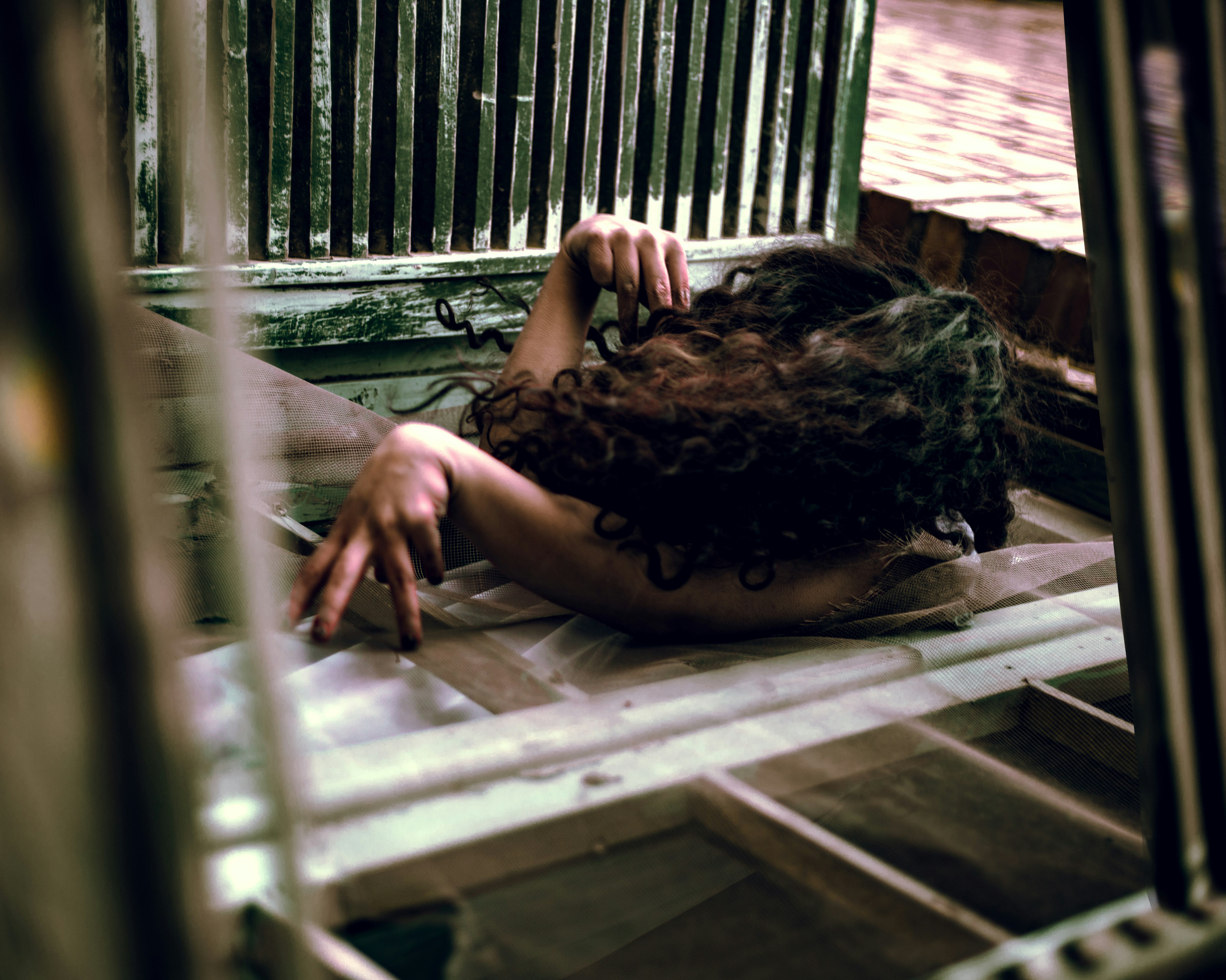 a woman laying on the ground in front of a window