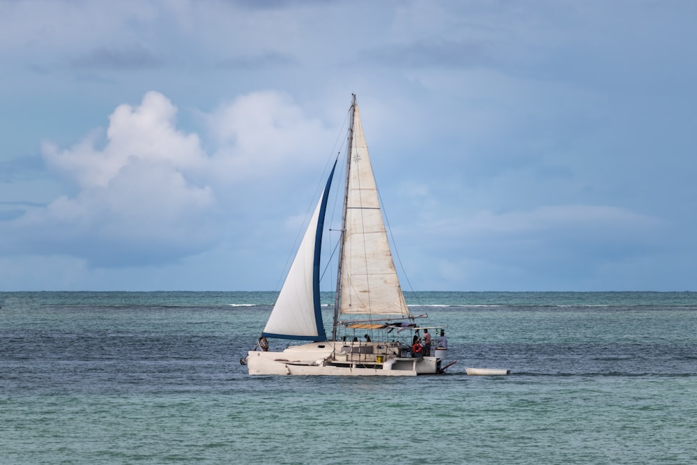 a sailboat with people on it in the ocean