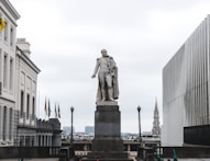 a statue of a man standing in front of a building