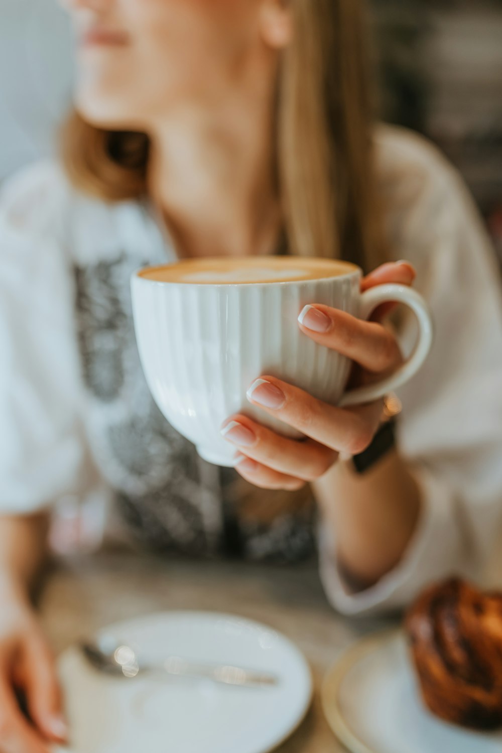 a woman is holding a cup of coffee