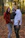 A smiling family posing outdoors with autumn leaves around them.
