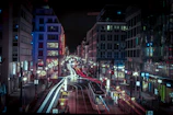 A lively city street lit up at night, bustling with energy.
