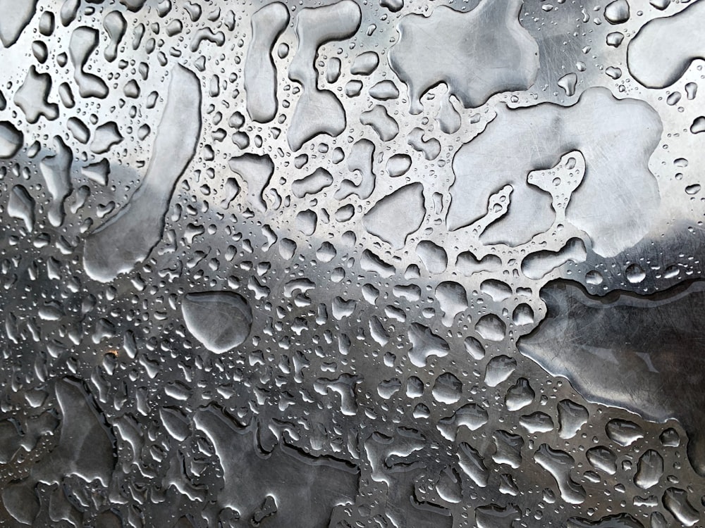 um close up de gotículas de água em uma superfície de metal