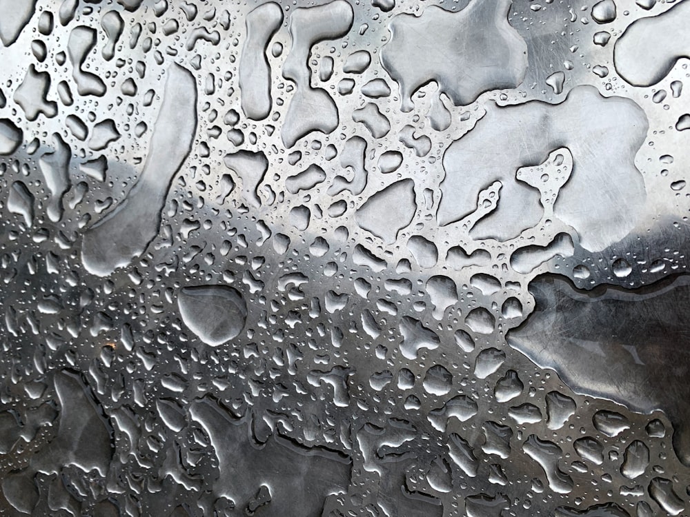 a close up of water droplets on a metal surface