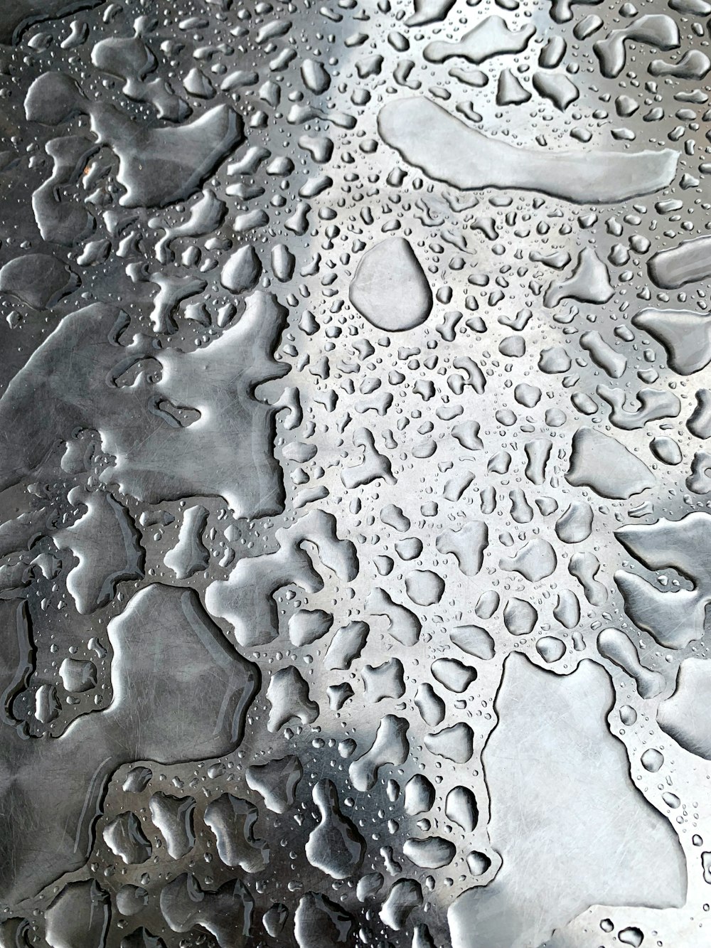 um close up de gotículas de água em uma superfície de metal