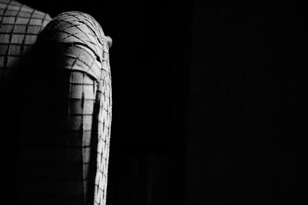 Close-up of rich black than cloth fabric with intricate texture under soft lighting.