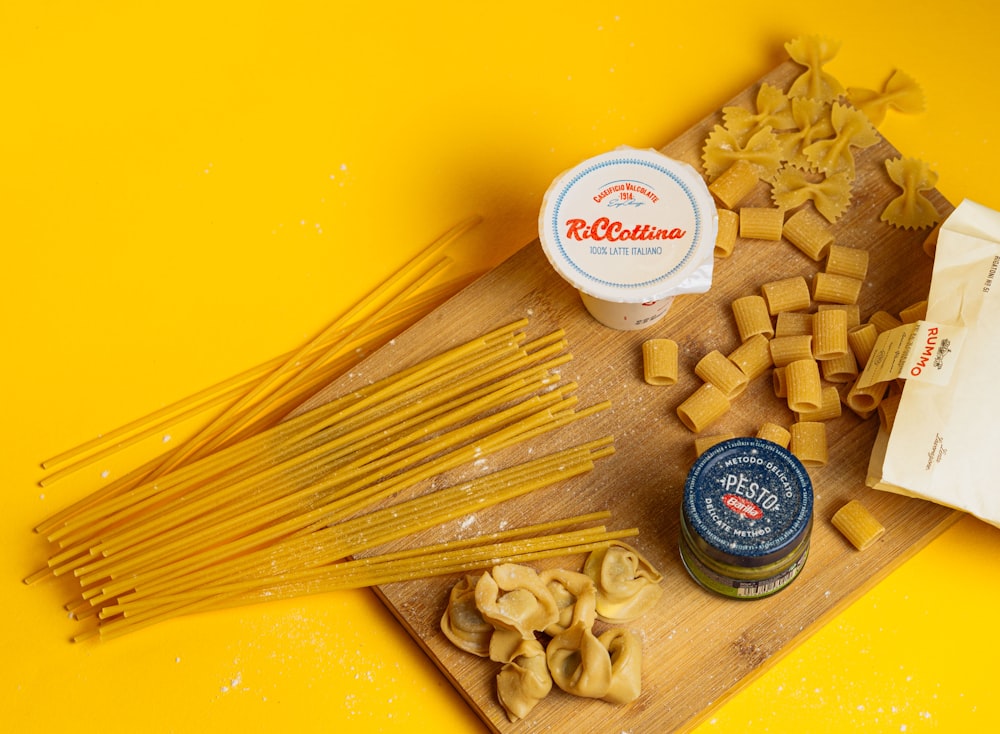 a wooden cutting board topped with lots of pasta