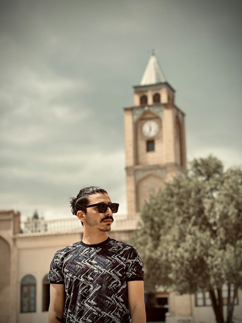 a man standing in front of a clock tower