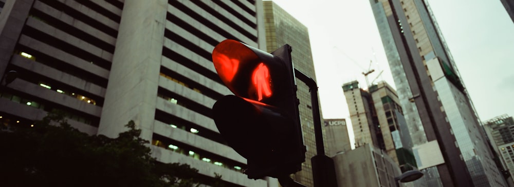 a traffic light in a city with tall buildings in the background