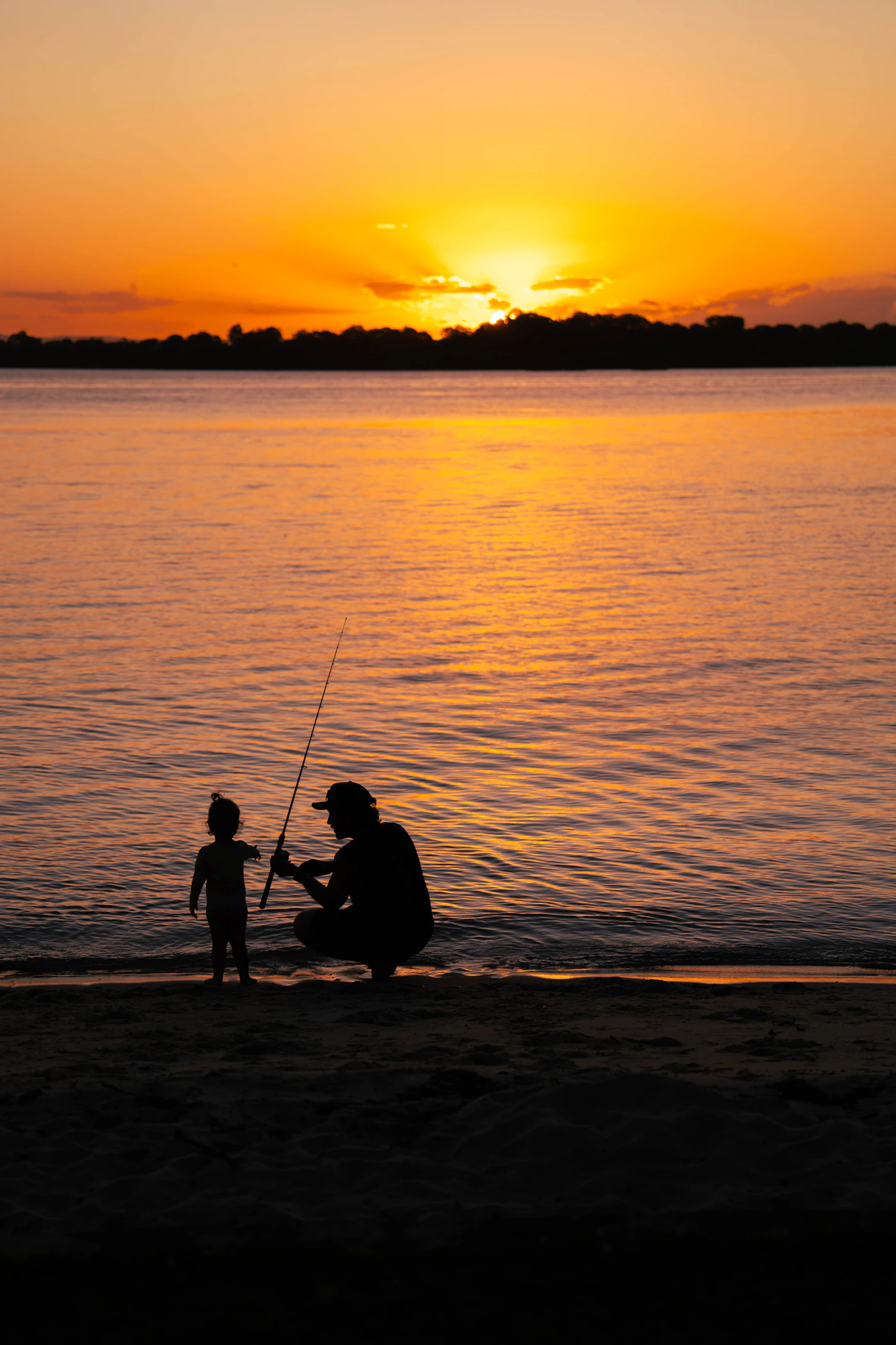 Vater und Sohn am Strand bei Sonnenuntergang