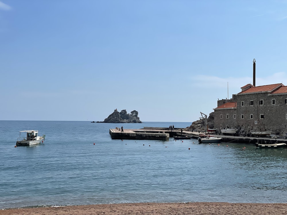 a small boat is in the water next to a building