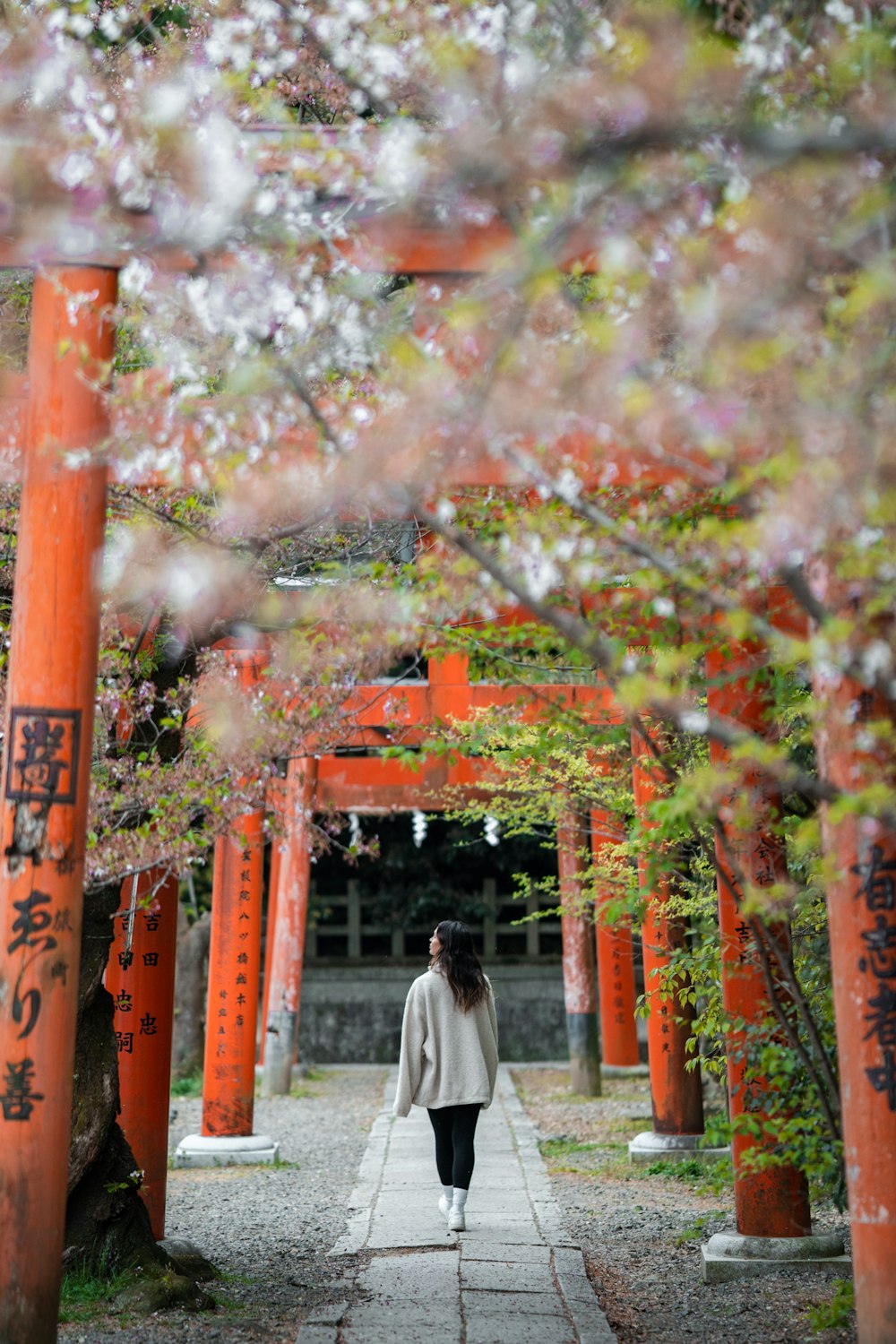 a woman walking down a path in a park