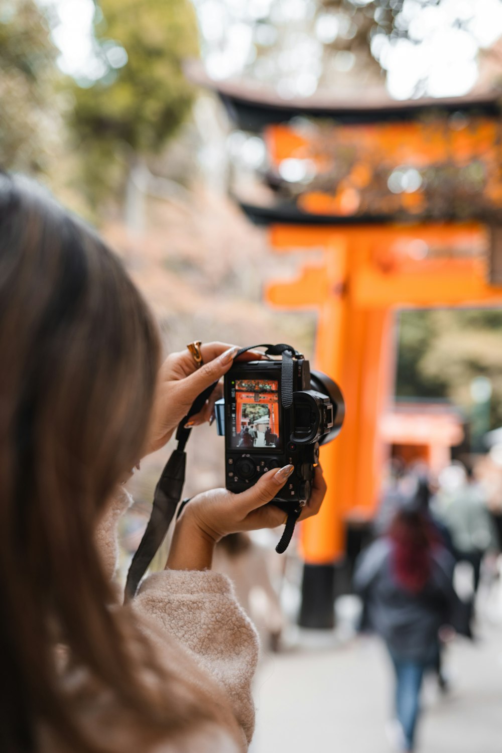 a woman taking a picture of an orange tori 