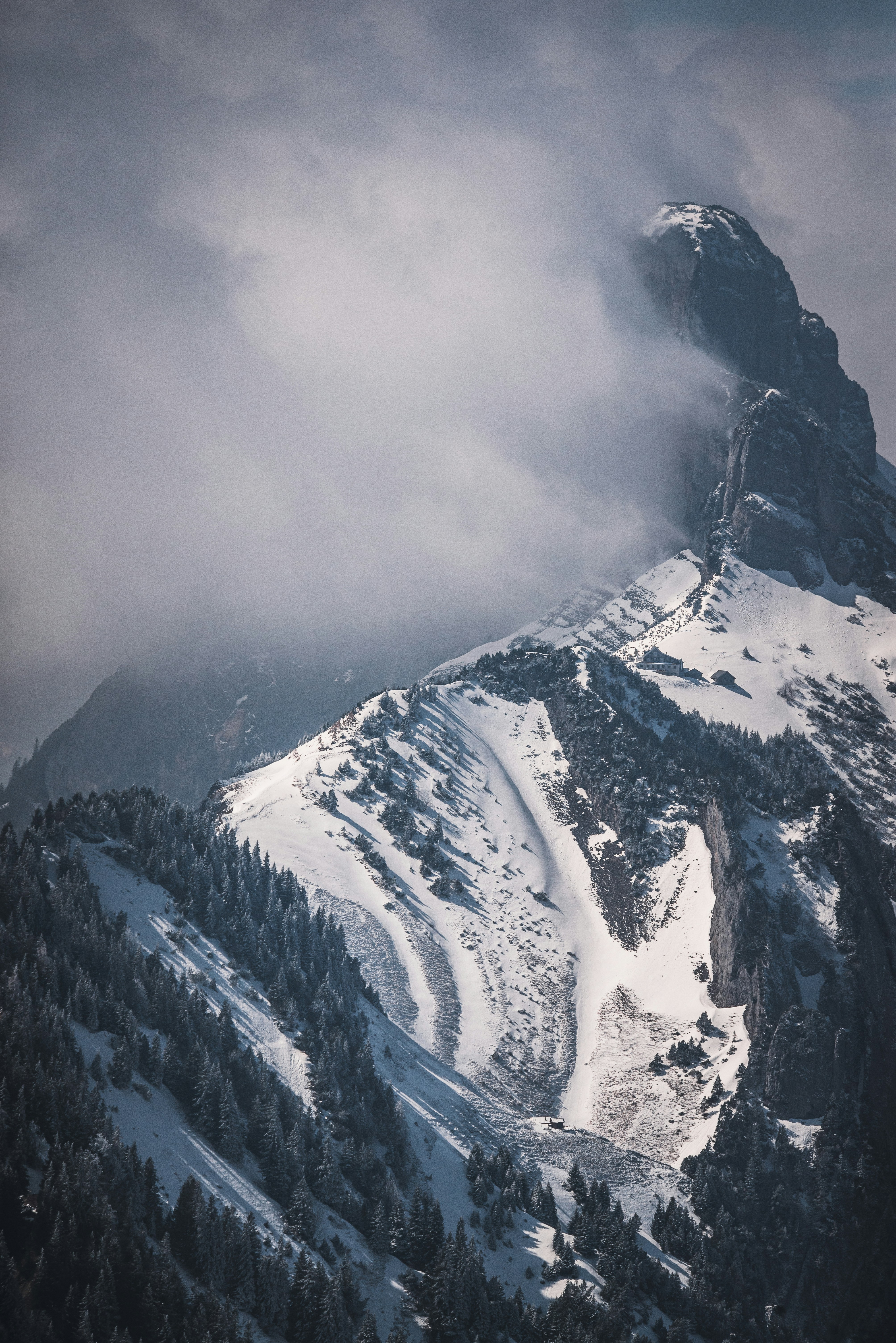 a mountain covered in snow and clouds
