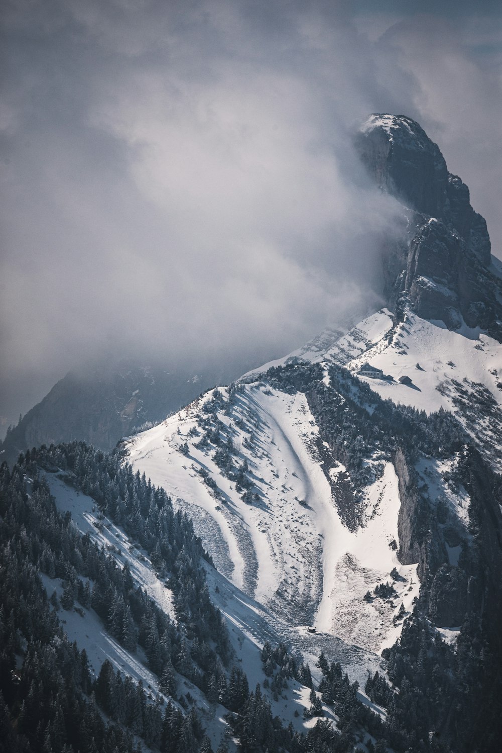 a mountain covered in snow and clouds