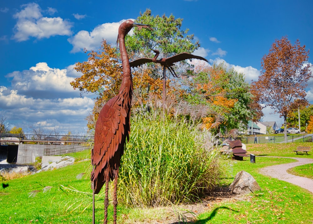a statue of a large bird in a park