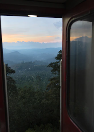 A scenic view from the train window capturing rolling hills and a bright blue sky.