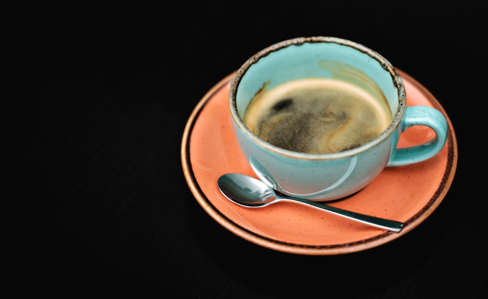 a cup of coffee on a saucer with a spoon