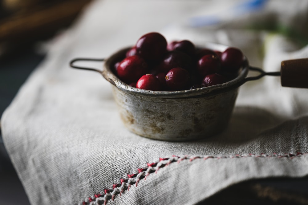 a bowl of cherries sitting on a table