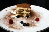 A beautifully plated tiramisú dusted with cocoa powder, inviting and rich.