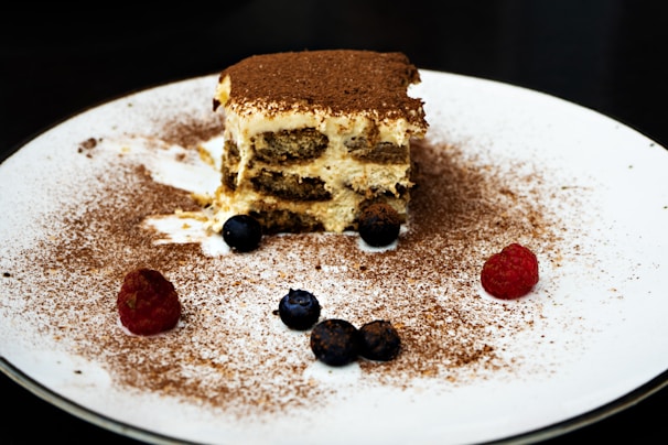 A close-up of a delicious slice of tiramisu on a plate.