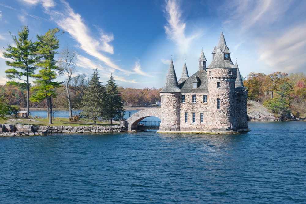 a castle sitting on top of a lake surrounded by trees