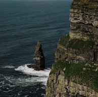 a large rock formation in the middle of a body of water