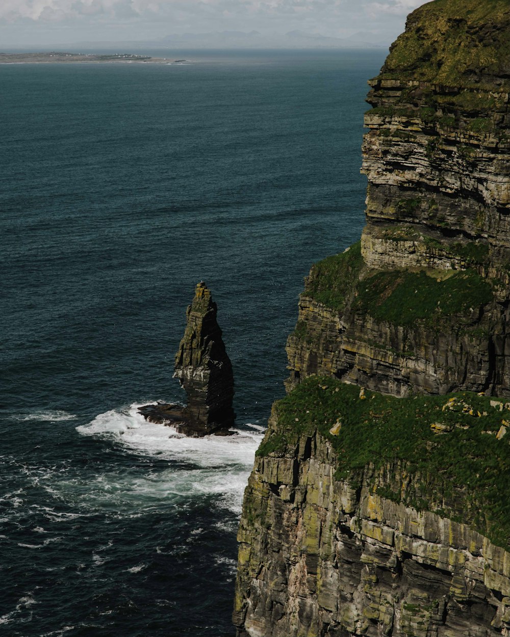 a large rock formation in the middle of a body of water