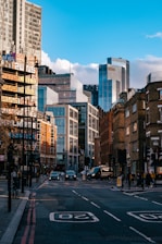 a city street with tall buildings in the background