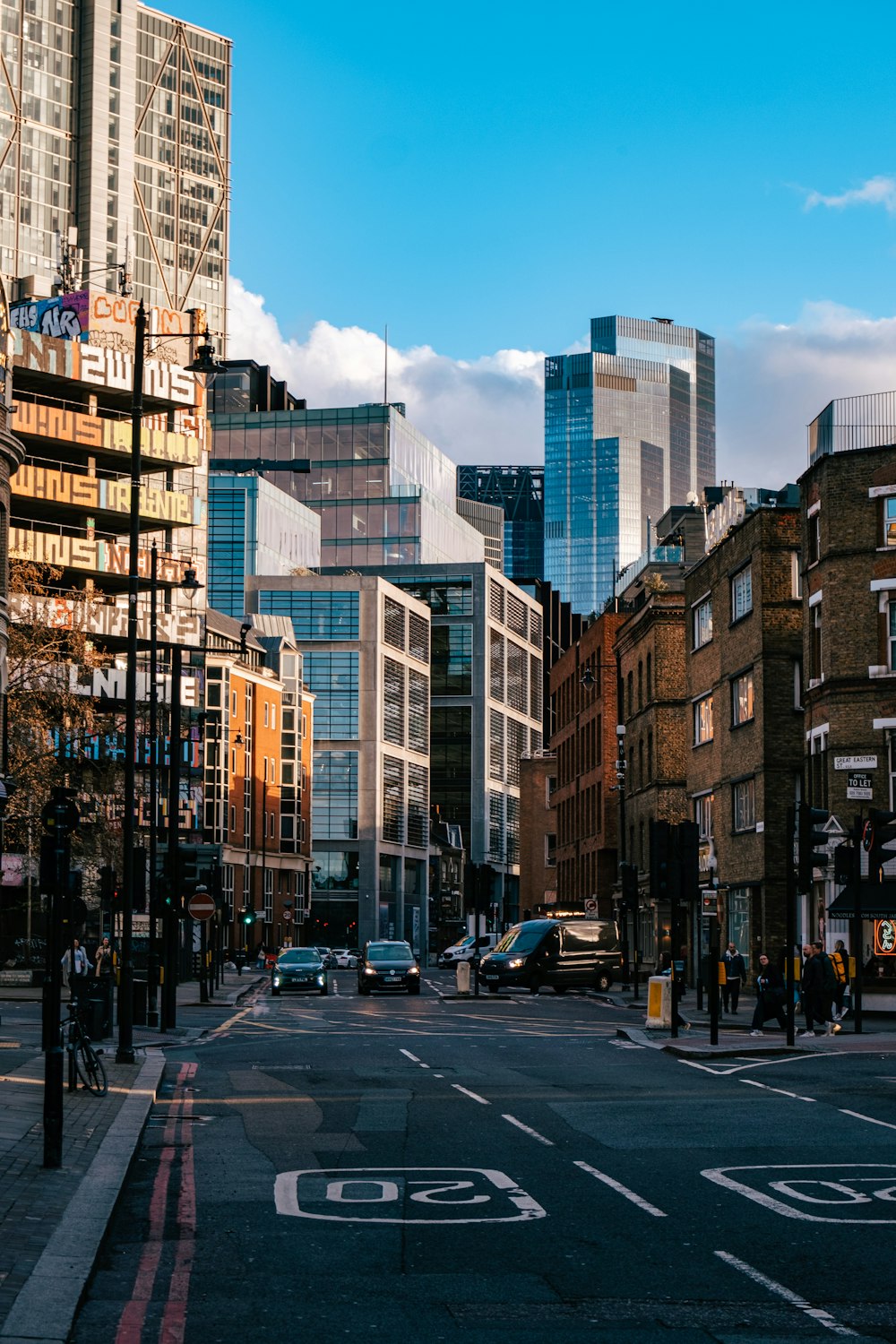 a city street with tall buildings in the background