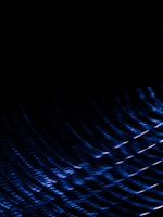 Dark background with an abstract pattern of blue light streaks creating a sense of motion and depth.