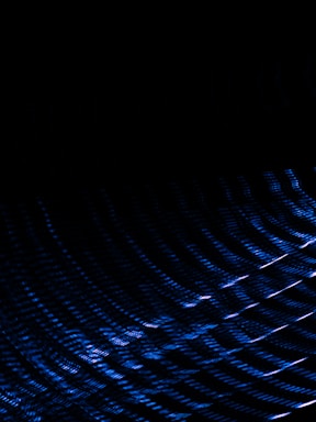 A sleek blue honeycomb pattern glowing softly against a dark space-like background.