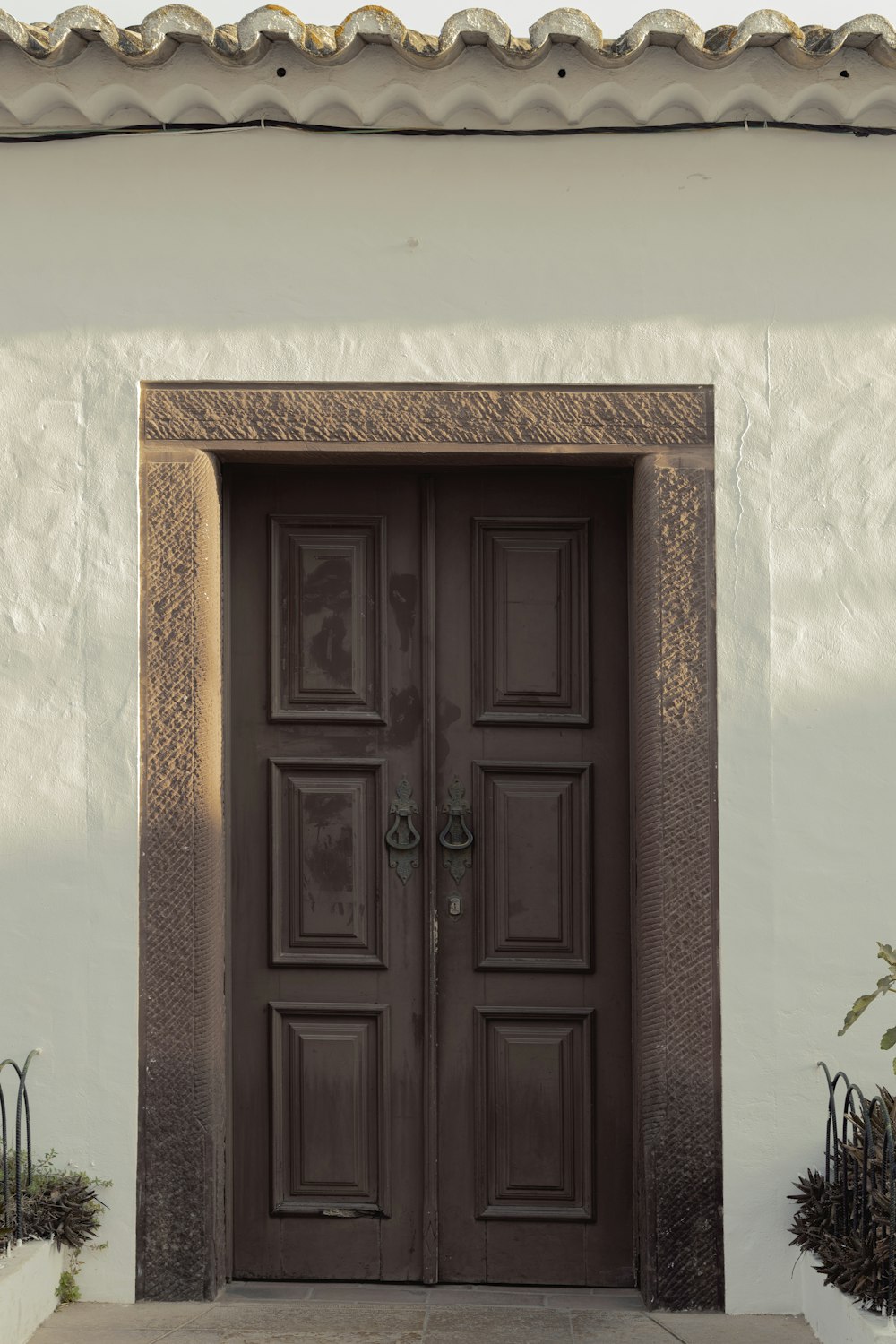 una grande porta marrone seduta accanto a un edificio bianco