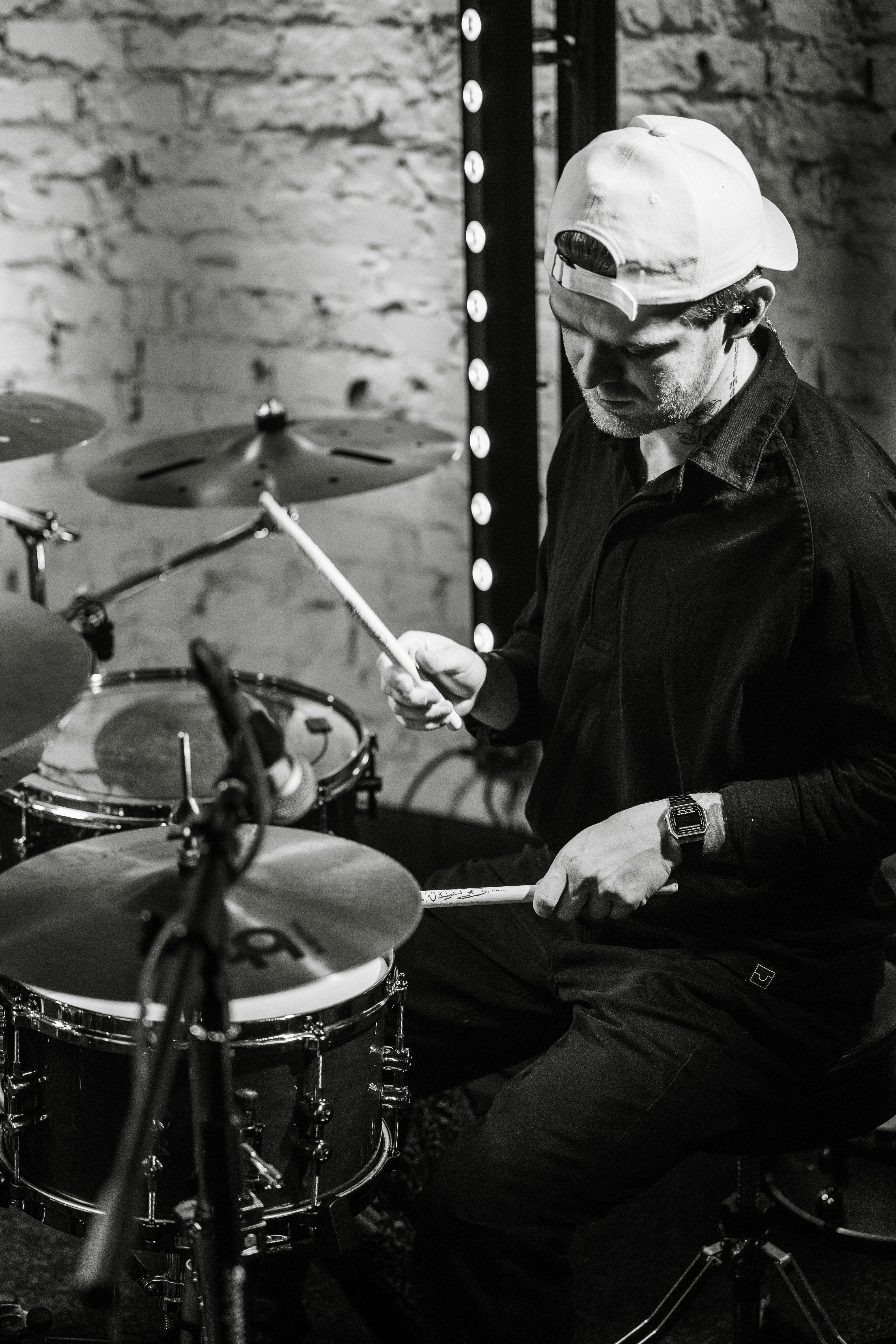 a man sitting in front of a drum set