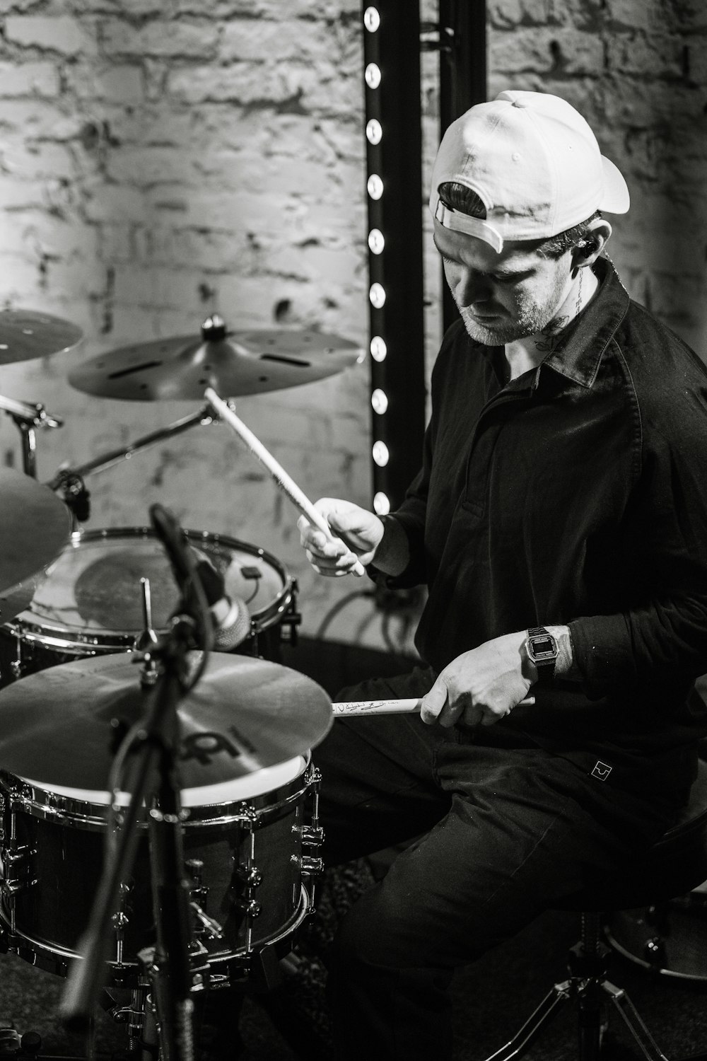 a man sitting in front of a drum set