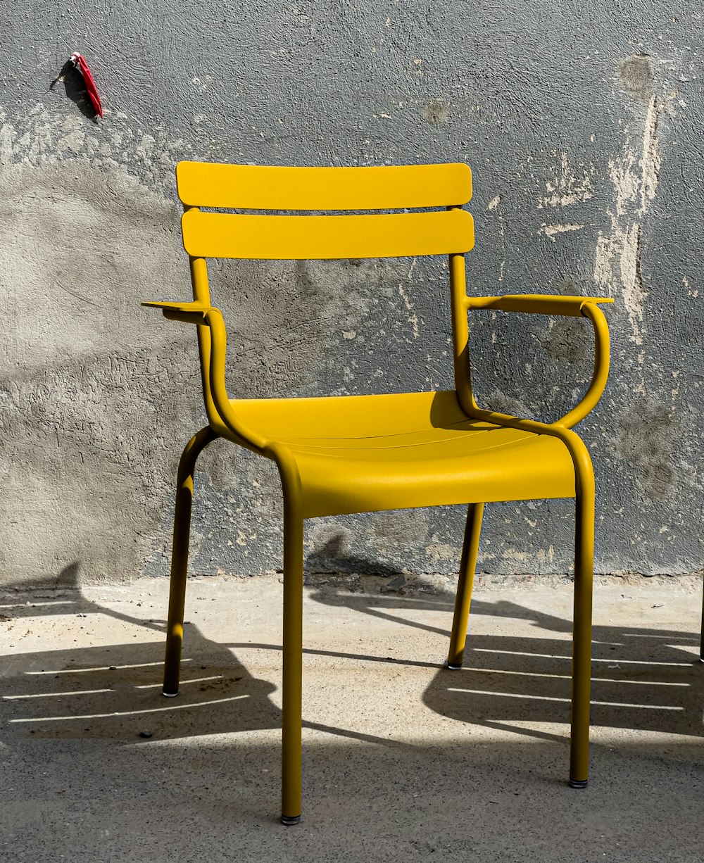 a yellow chair sitting in front of a gray wall