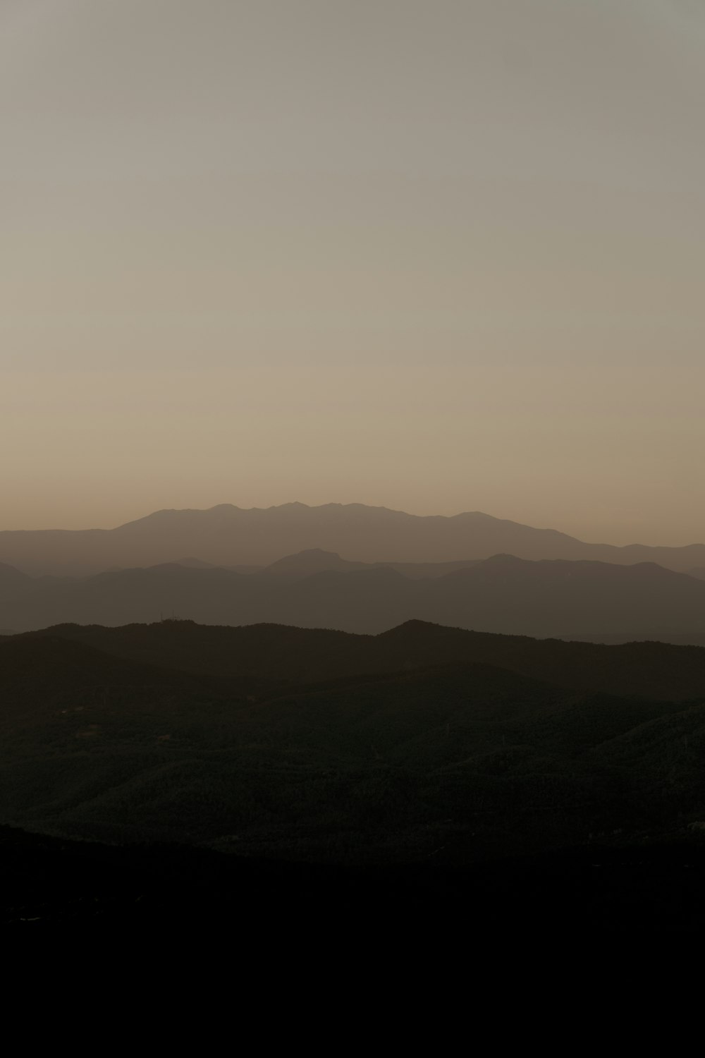 the sun is setting over the mountains in the distance