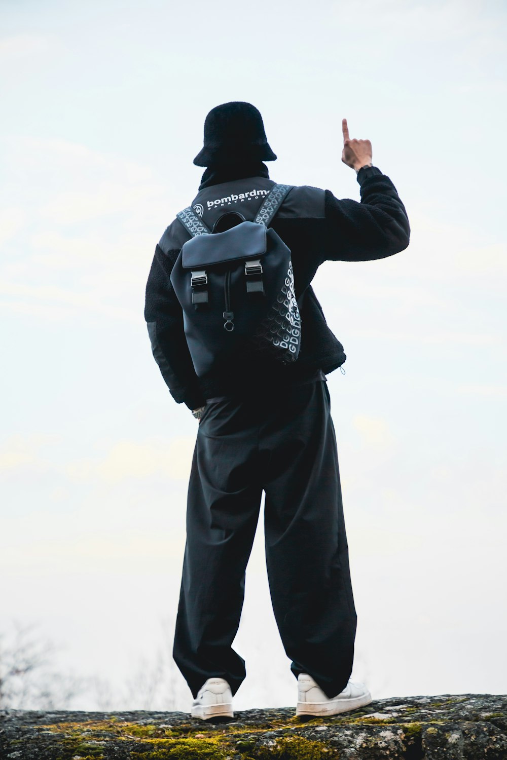 a man with a backpack on top of a rock