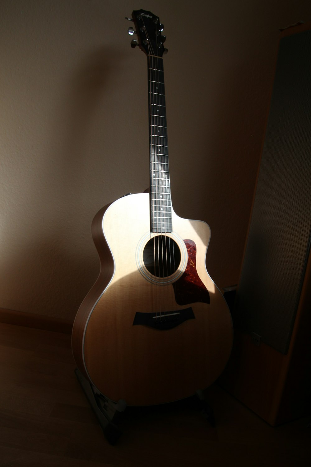 a guitar sitting on top of a hard wood floor