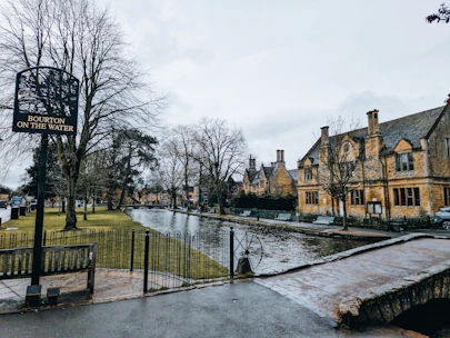 a river running through a park next to a tall building