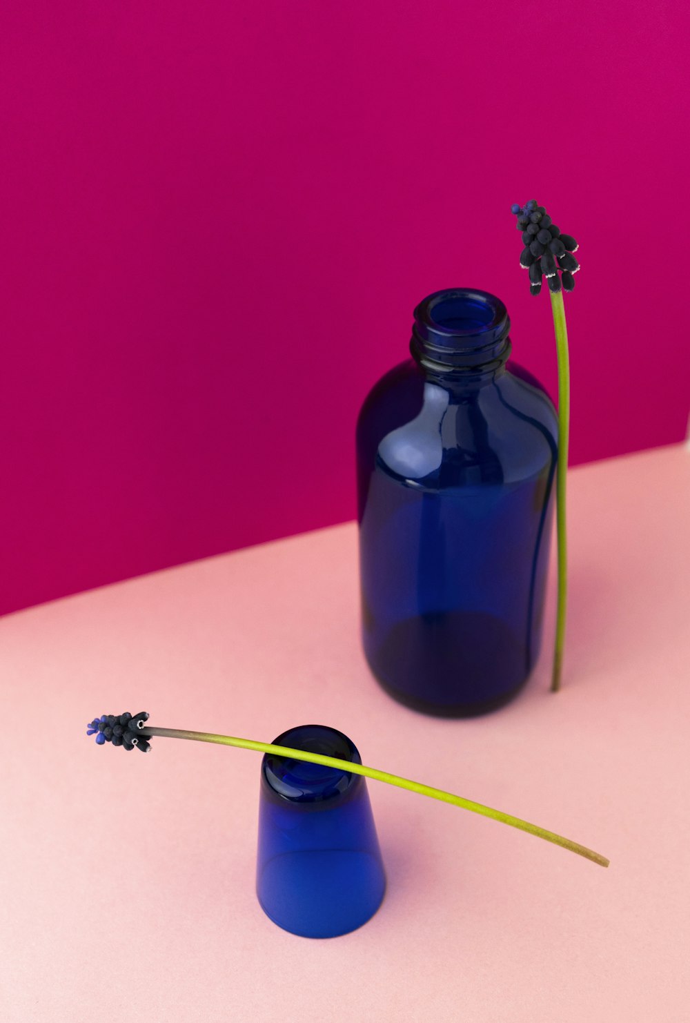 a blue glass bottle with a flower in it
