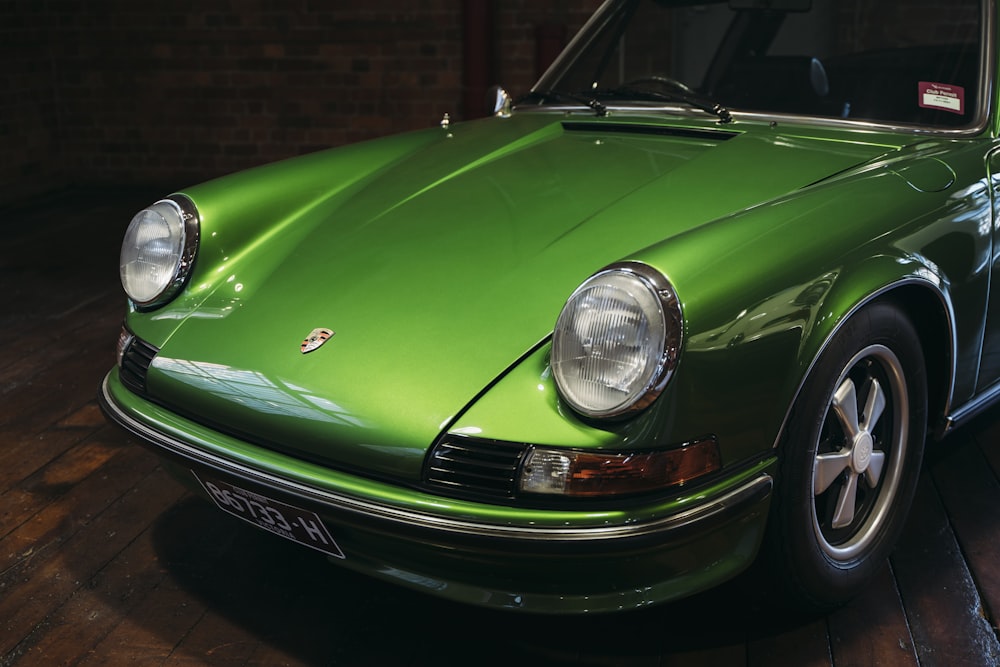 a green car parked in a garage next to a brick wall