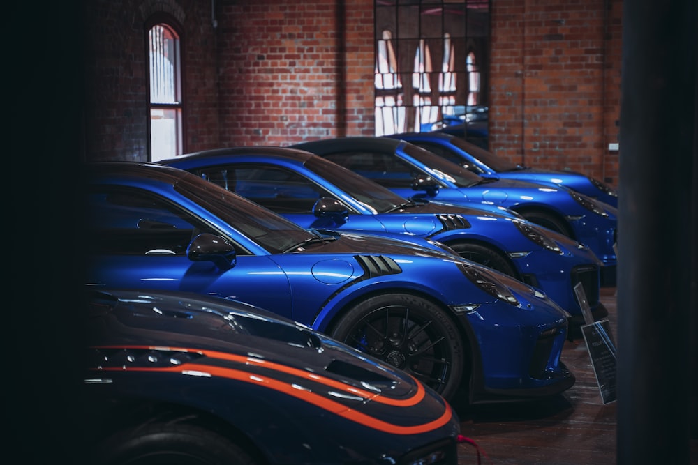 a row of blue sports cars parked next to each other